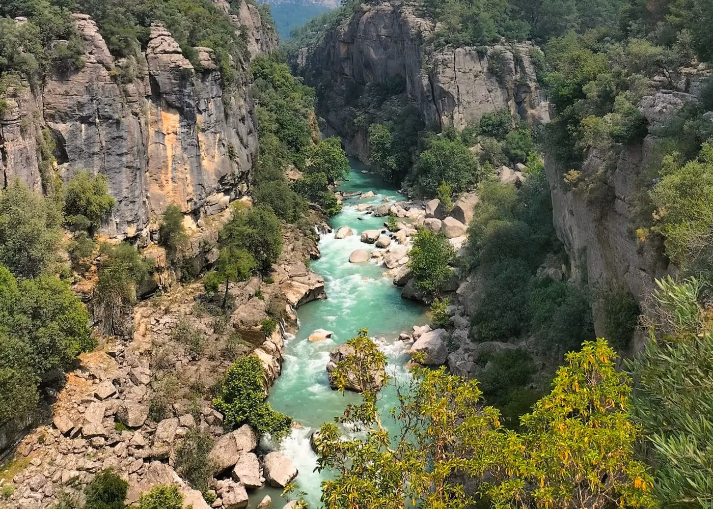 Diepe kloof met een rivier op de bodem en bomen langs de randen, Köprülü