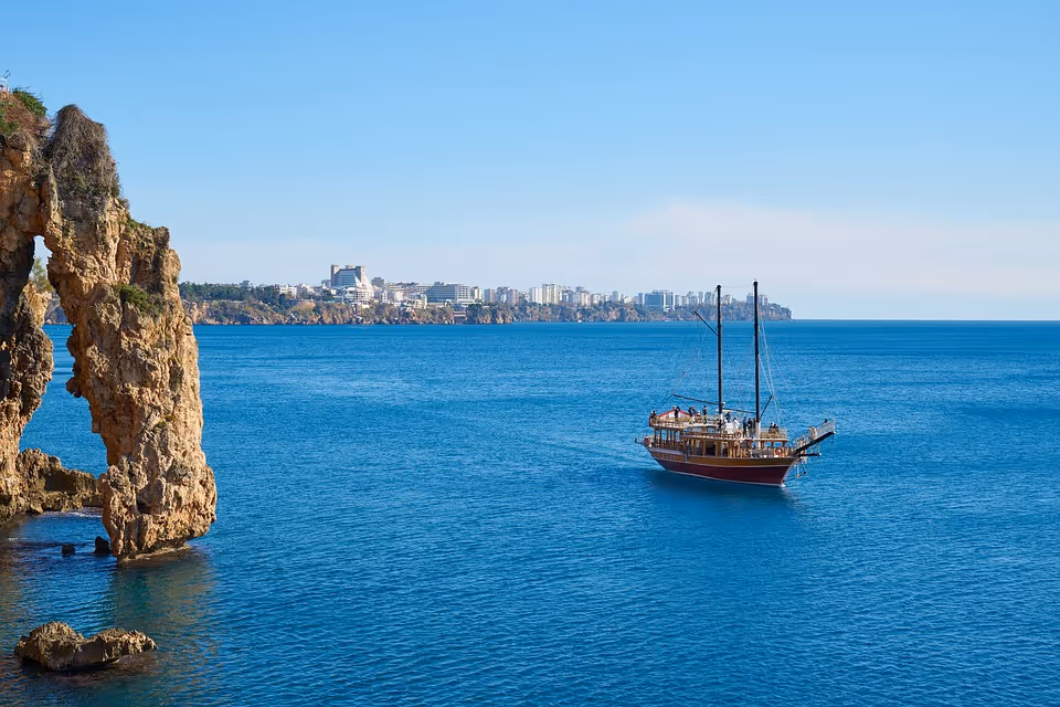 Rotsboog en zeilschip aan de kust bij Antalya
