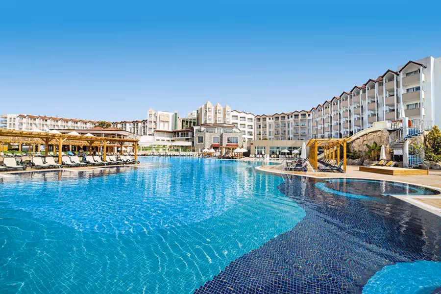 Groot zwembad met de hotelgebouwen erachter bij Arcanus Side Resort in Sorgun