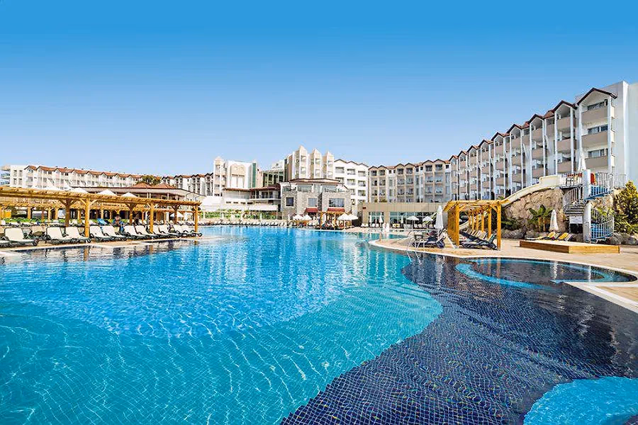 Groot zwembad met de hotelgebouwen erachter bij Arcanus Side Resort in Sorgun