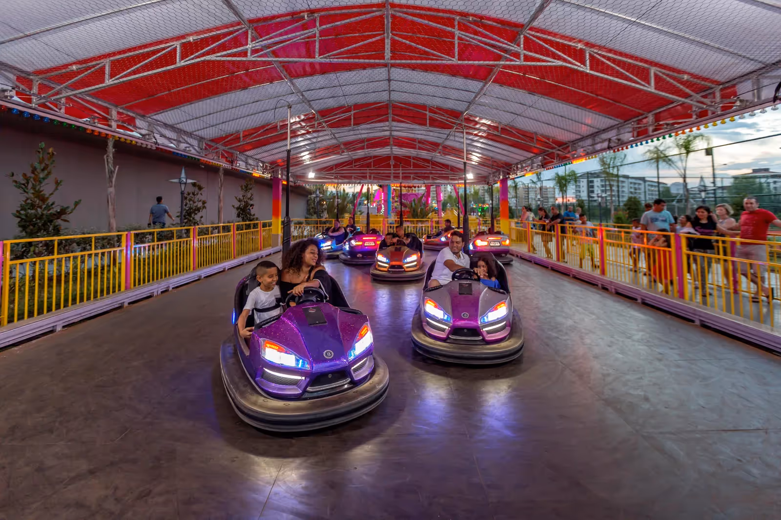 Botsauto's onder een overdekte kap met rode spanten in het lunapark van Royal Seginus in Lara