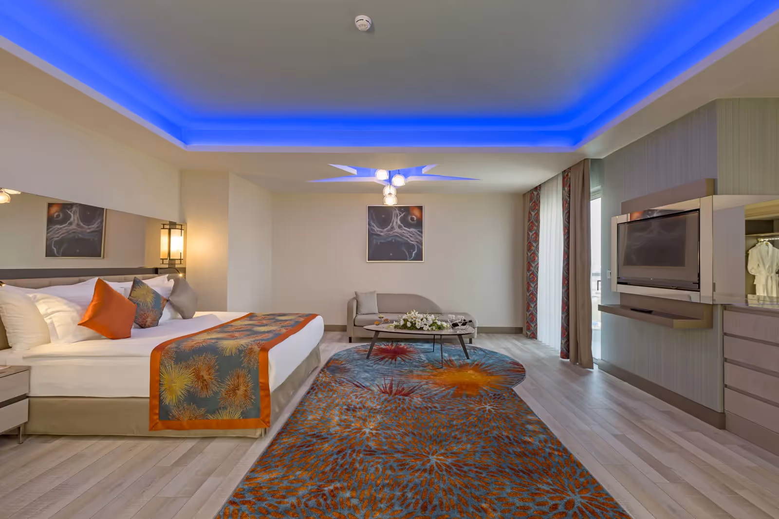 Grote kamer met een tweepersoonsbed, een zithoek en een blauw verlicht plafond bij Royal Seginus in Lara