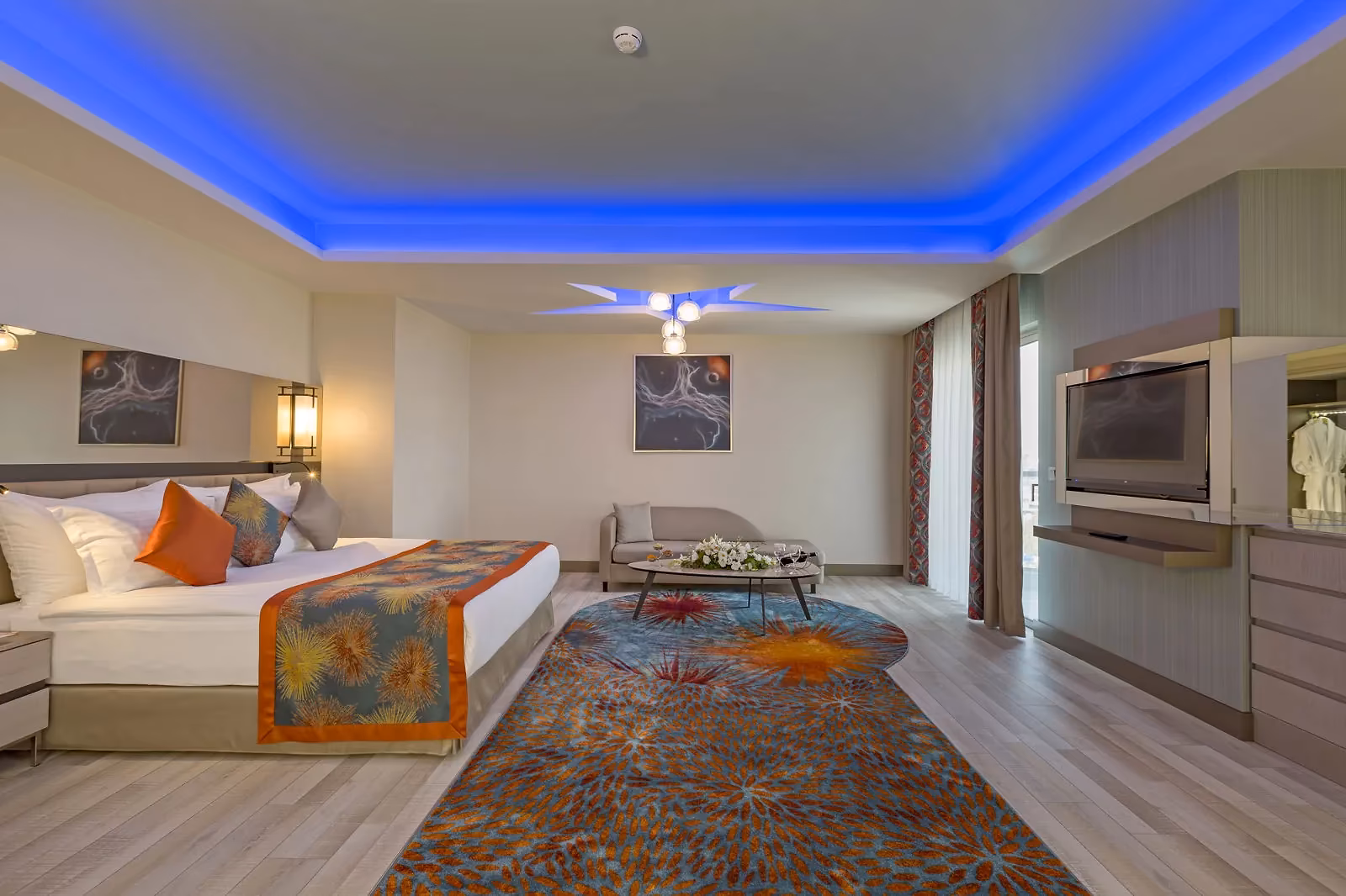 Grote kamer met een tweepersoonsbed, een zithoek en een blauw verlicht plafond bij Royal Seginus in Lara