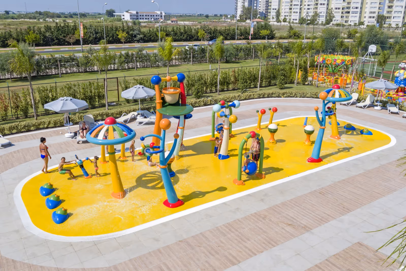 Gele speelplek met paddenstoelvormige watersproeiers bij het kinderbad van Royal Seginus in Lara